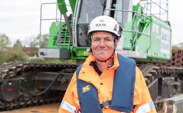 Slide Portrait Domarin Bauleiter DI Bernhard Faltl vor Domarin Bagger