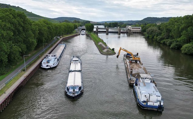 Slide Ein Baggerponton mit einem Bagger auf dem Wasser